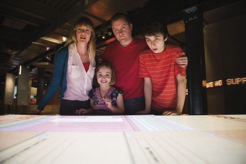 Una famiglia esplora il tavolo interattivo del Churchill Museum