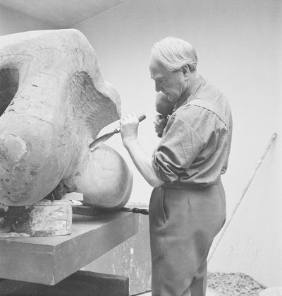 Henry Moore carving Reclining Figure 1959-64 in elm wood.