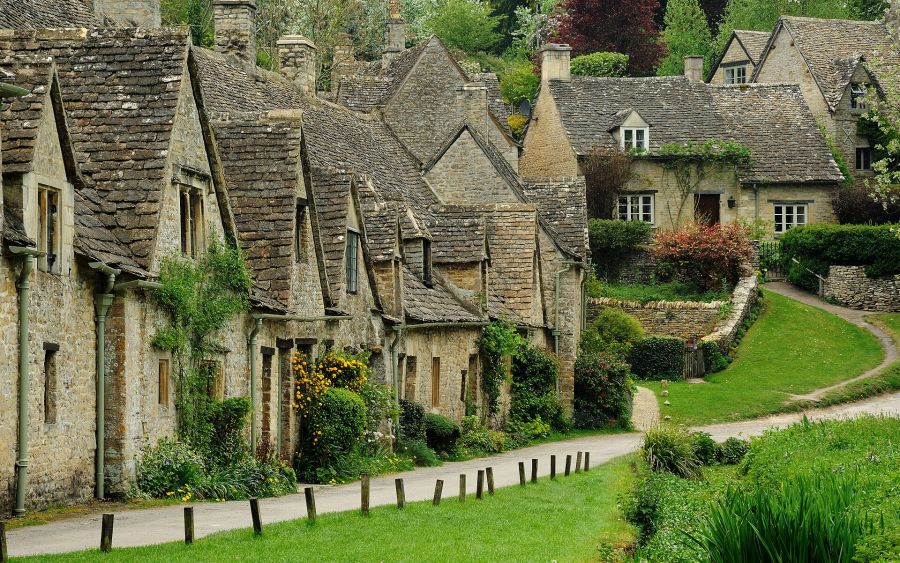 La fila di cottage in pietra di Arlington Row a Bibury, con il sentiero e il prato davanti