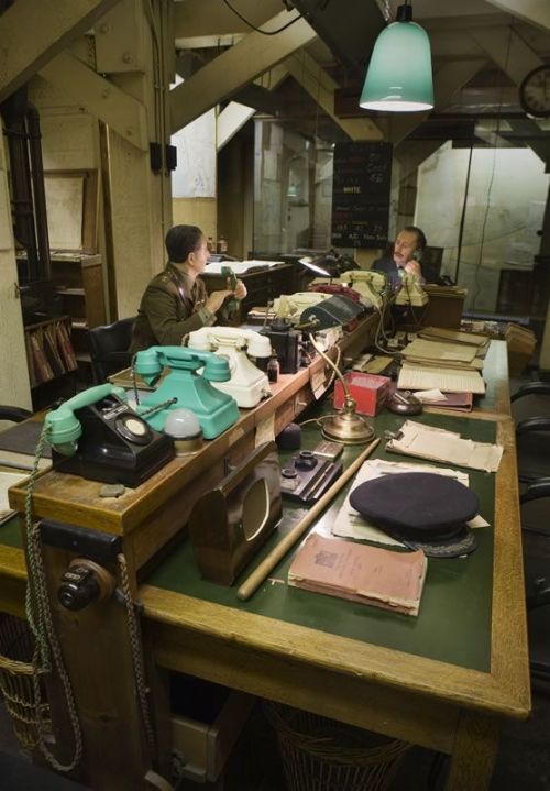 Le scrivanie della Map Room con i telefoni colorati e i manichini degli ufficiali di guardia