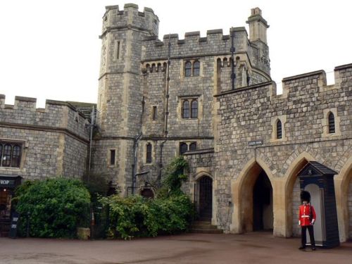 Una guardia in uniforme rossa e colbacco di pelo di guardia all'ingresso del Castello di Windsor